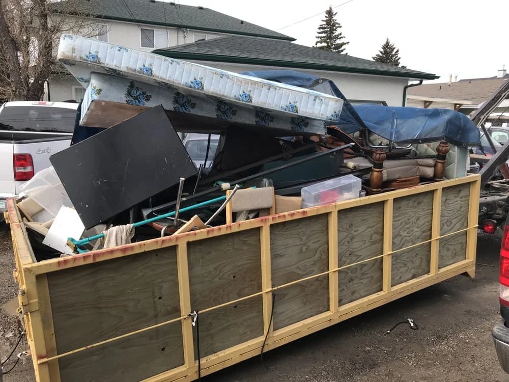 Bin loaded with mattress and furniture for junk removal in Calgary